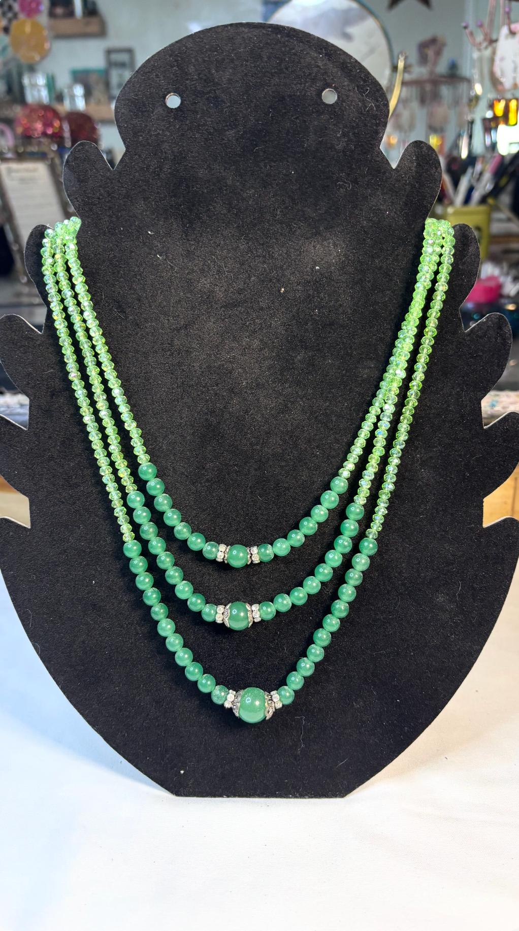 Green beaded 18 inch layered necklace on a black display bust