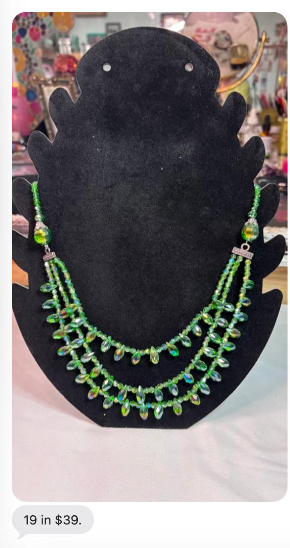 Green crystal 19 inch statement necklace on a black display bust