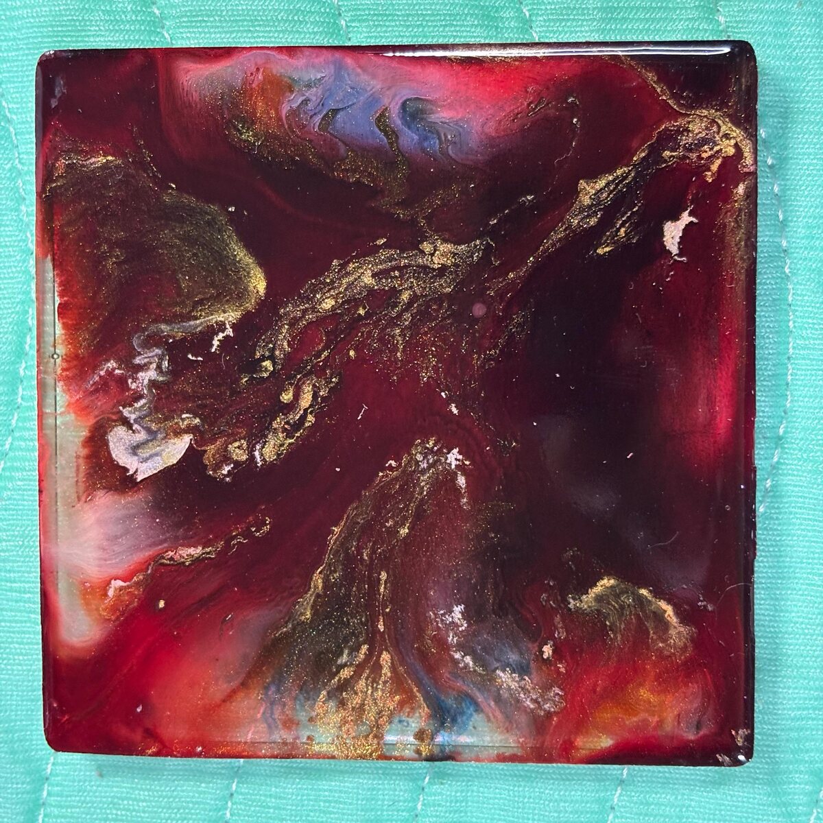 Burgundy square resin coaster with gold and dark galaxy-like movement