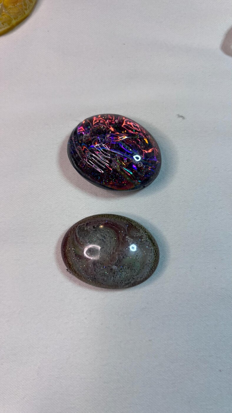 Two dark oval handmade resin stones